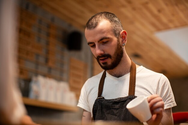 Close-up of man with apron holding on empty cup