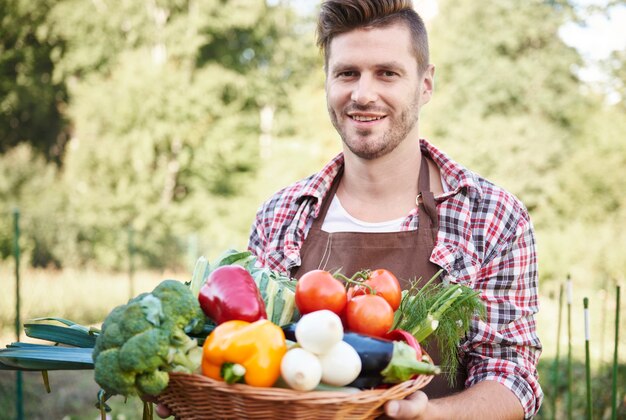 野菜でいっぱいのバスケットで男にクローズアップ