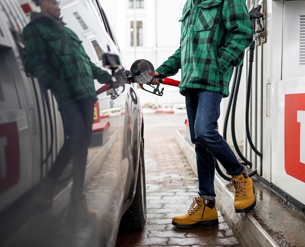 ガソリンスタンドで車で男を閉じる