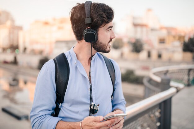 Close-up of a man with cellphone looking away