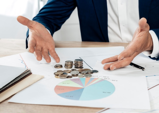 Close-up man with coins and statistics