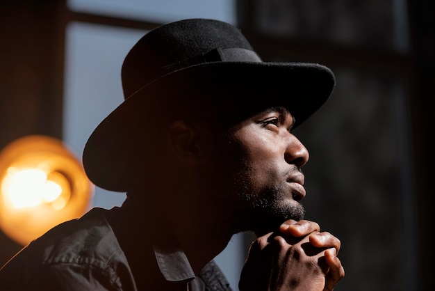 Uomo del primo piano con la posa del cappello