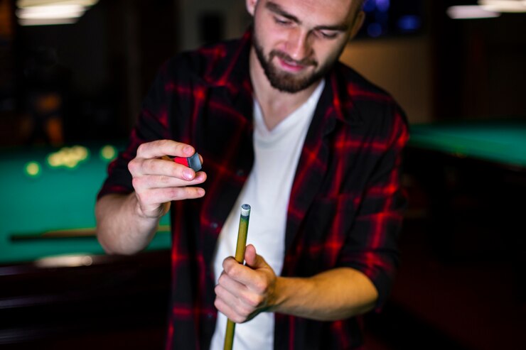 Free Photo close-up man with pool cue and chalk 