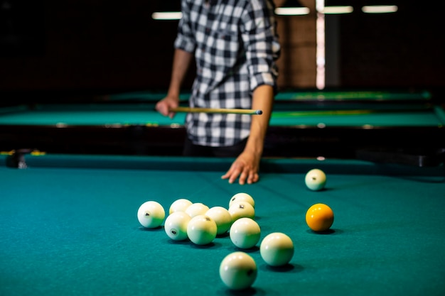 Close-up man with pool cue and white balls 