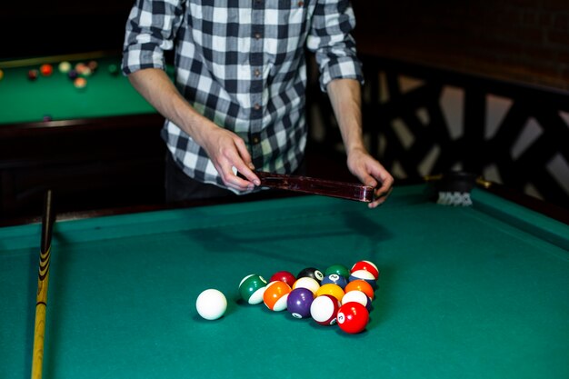 Close-up man with pool triangle and balls