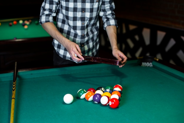 Close-up man with pool triangle and balls
