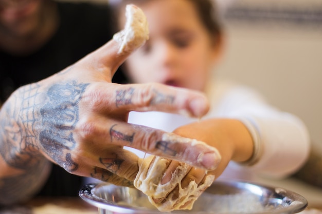 Close-up of man with son kneading dough