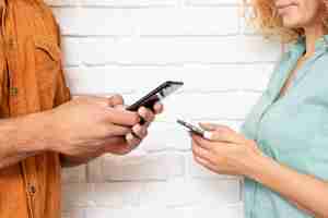 Free photo close-up man and woman with phones