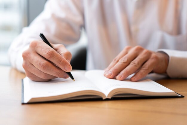 Close up man writing in agenda