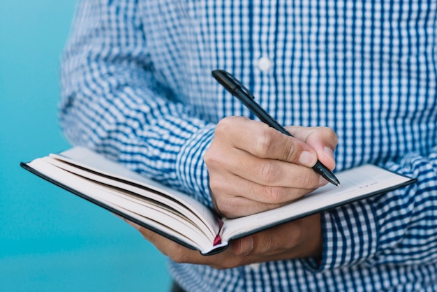 Close up of man writing in book