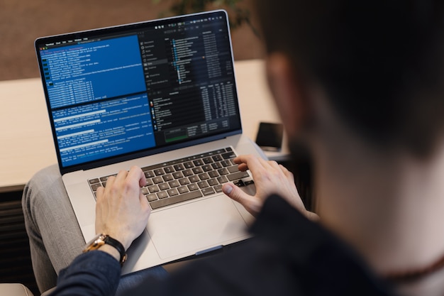 dedicated laravel developers Close up man writing code on the laptop Free Photo