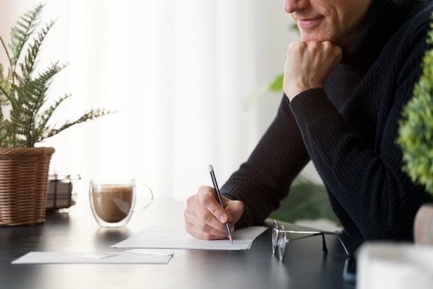 Foto gratuita chiuda sulla lettera di scrittura dell'uomo