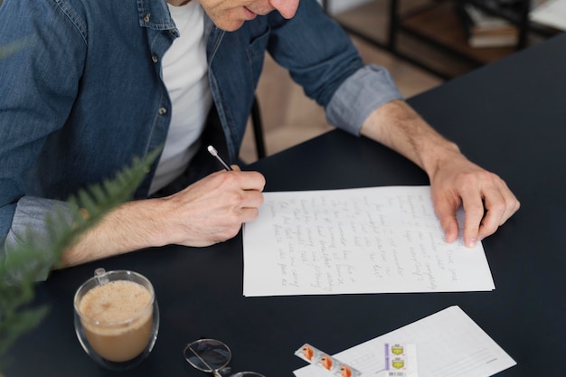 Free photo close up man writing letter