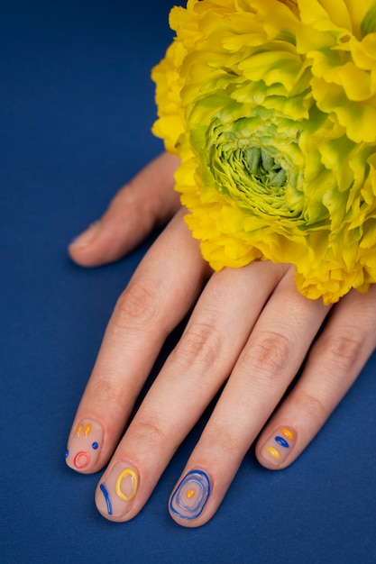 Primo piano manicure con fiore giallo