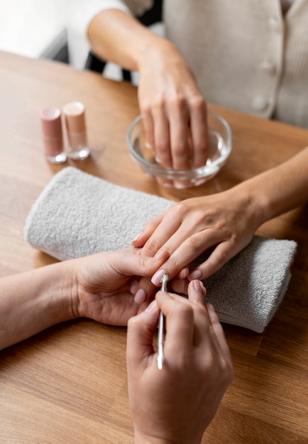 Close up manicurist holding nail tool