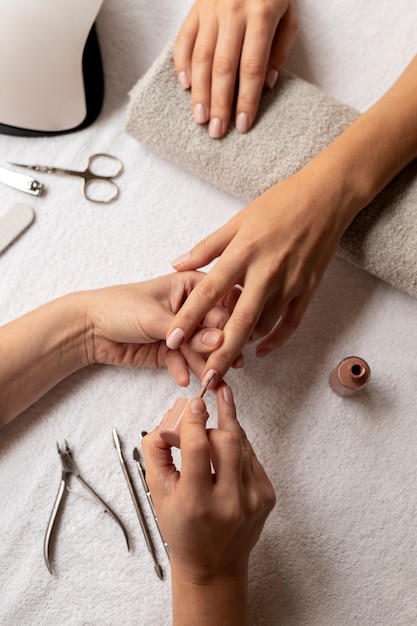 Close up manicurist using nail polish