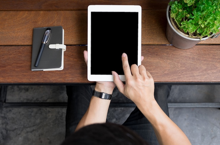 Free Photo close up of mans hands using tablet on counter, image taken from above