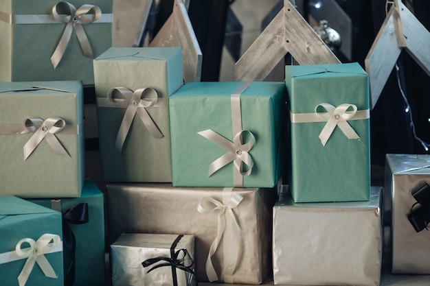 Close-up of many Christmas presents with bows on the floor. Stack of beautiful wrapped Christmas gifts from Santa on the floor.