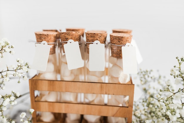 Close-up of marshmallow test tubes with tag in crate on marble background