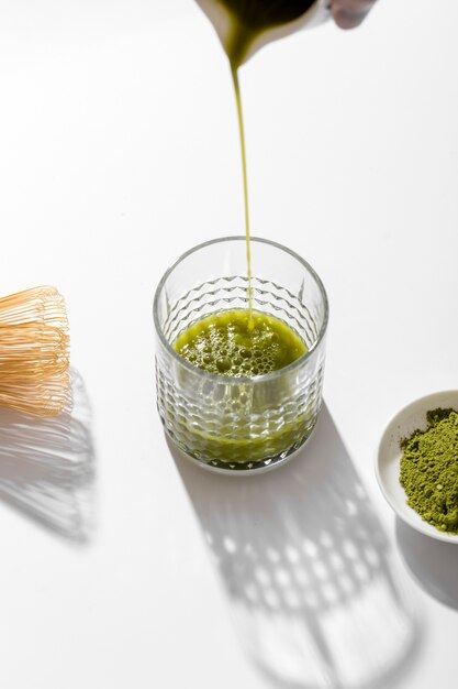 Close-up matcha tea pouring into glass