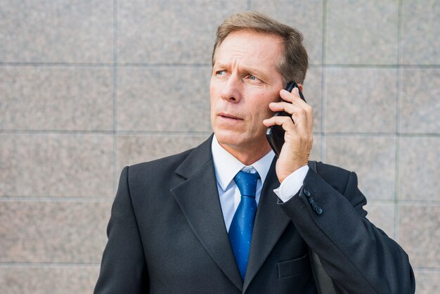 Крупный план зрелого бизнесмена, говорить на смартфоне