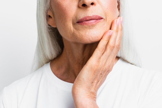 Free photo close-up mature woman applying skin care