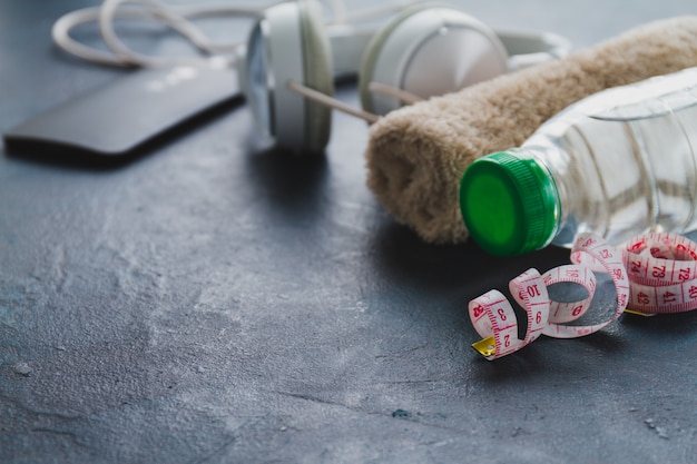 Close-up of measuring tape with bottle and towel