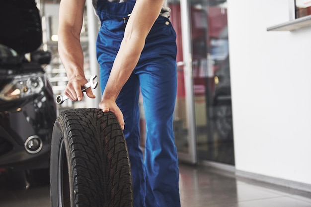 Close up of mechanic showing ok gesture with his thumb while holding a wrench.