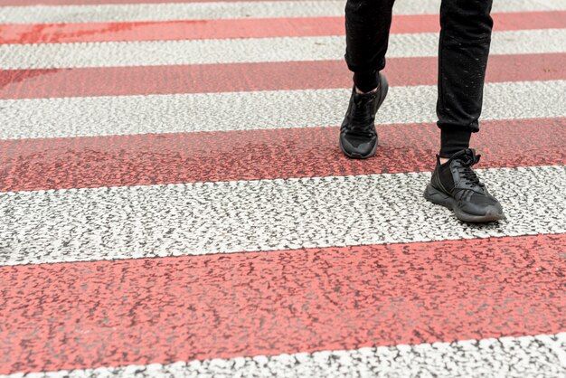 Close-up men legs passing a crosswalk