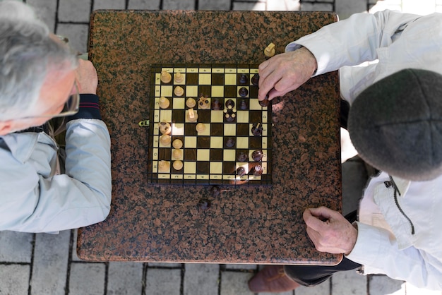 Foto gratuita chiuda in su uomini che giocano a scacchi insieme all'aperto