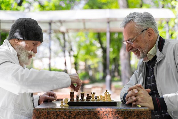 Close up men playing chess together outside