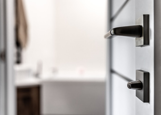 close-up of metal doorknob on blurred background of home interior.