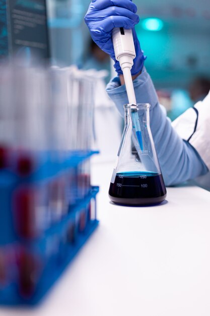 Close up of micropipette dipping in test tube for science experiment