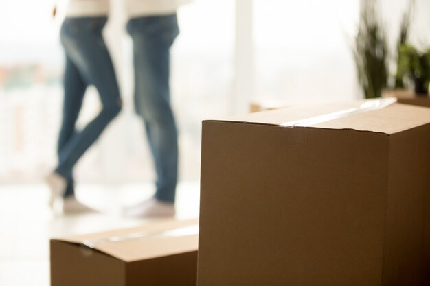 Close up of millennial couple moving to new home with boxes