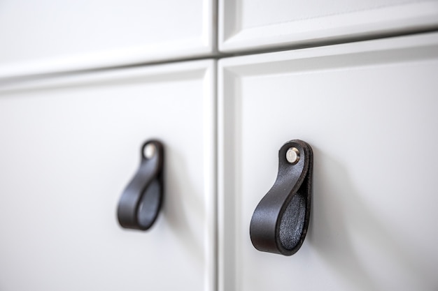 Free photo close up of minimalistic white furniture with black handles, kitchen cabinet, details.