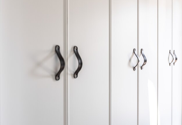 Free photo close up of minimalistic white furniture with black handles kitchen cabinet details