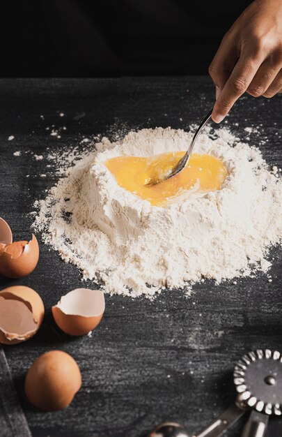 Close-up mixing flour and yolk with spoon