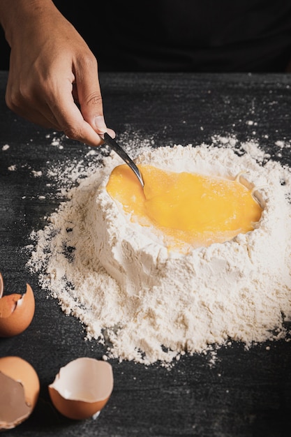 Close-up mixing flour and yolk with spoon