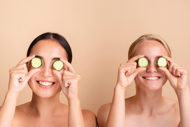 Close-up models posing with cucumber slices