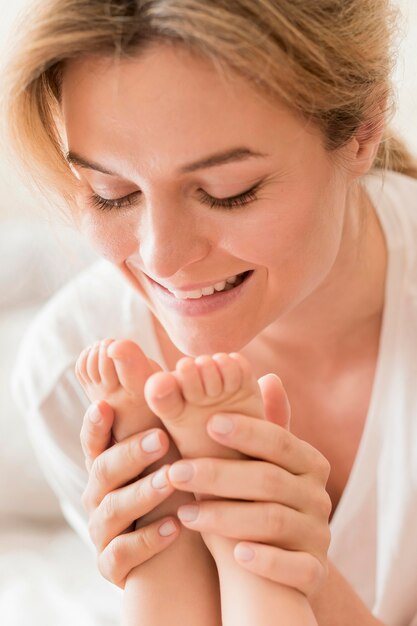 Close-up mom holding baby's feet