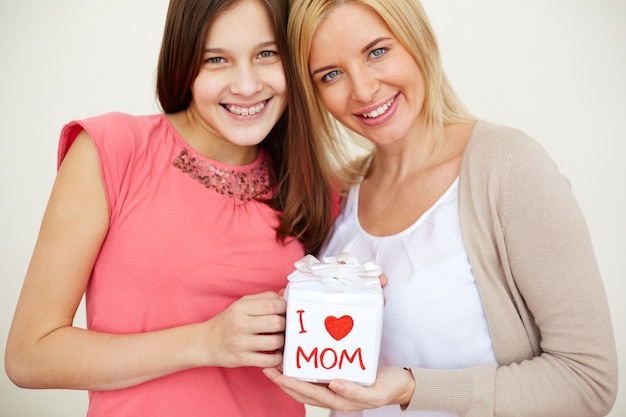 Free photo close up of mother and daughter with gift