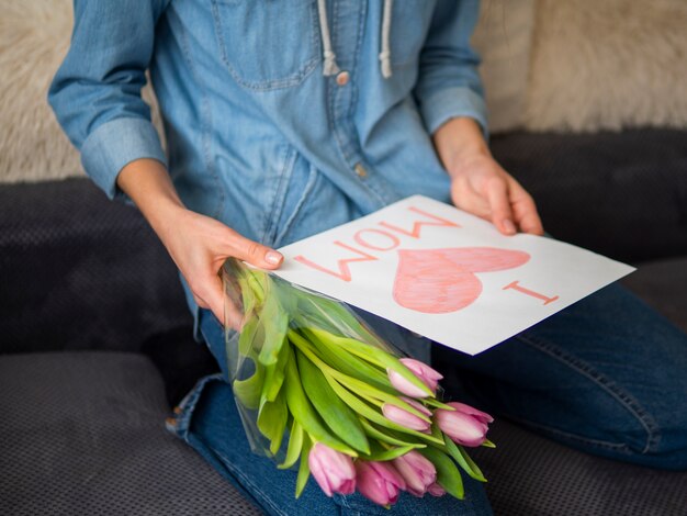 Close-up mother holding drawing and flowers