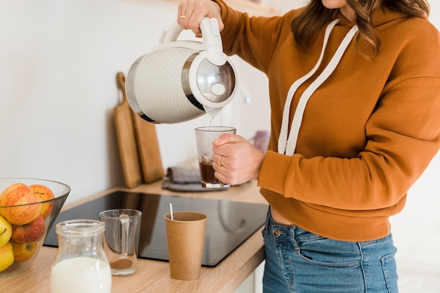 Foto gratuita madre del primo piano che prepara caffè