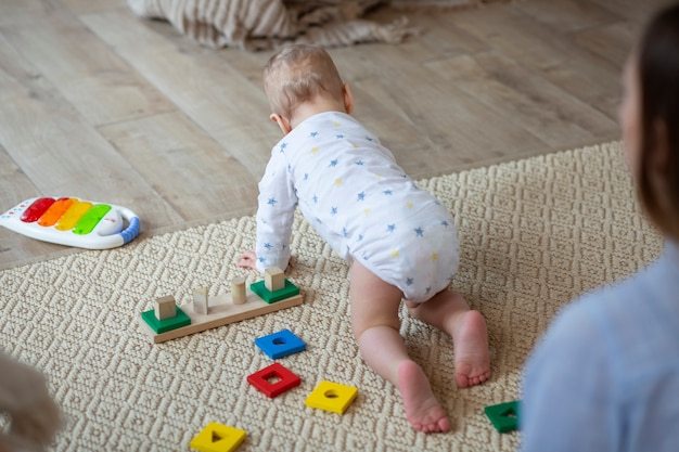 Free photo close up mother watching baby crawl