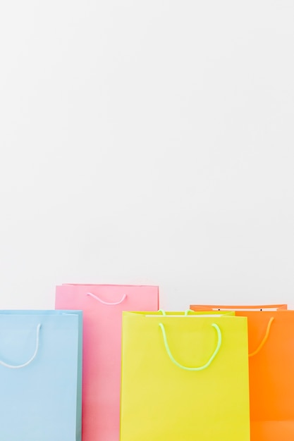 Close-up of multi colored shopping bags on white background