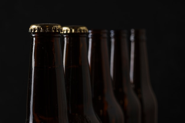 Close-up multiple beer bottles aligned