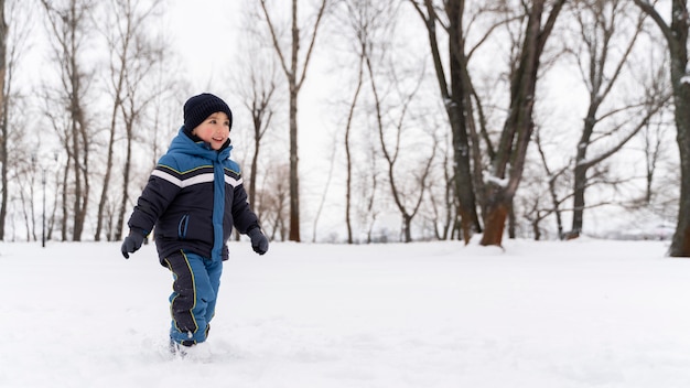 Закройте n счастливый ребенок, играющий в снегу