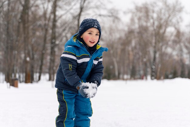 雪の中で遊んでいるn幸せな子供を閉じます
