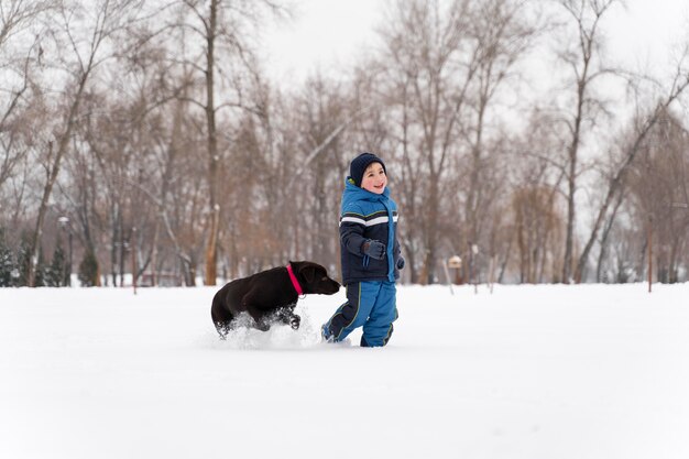 雪の中で遊んでいるn幸せな子供を閉じます