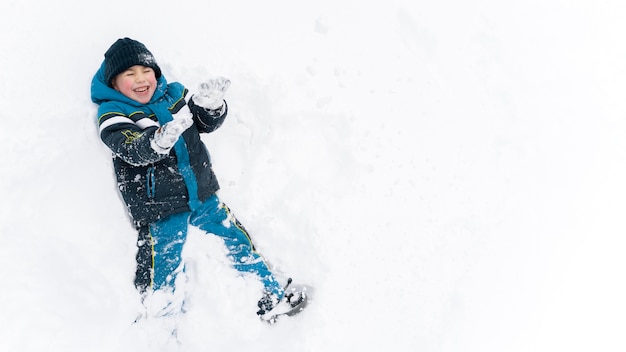 Free photo close up n happy kid playing in the snow